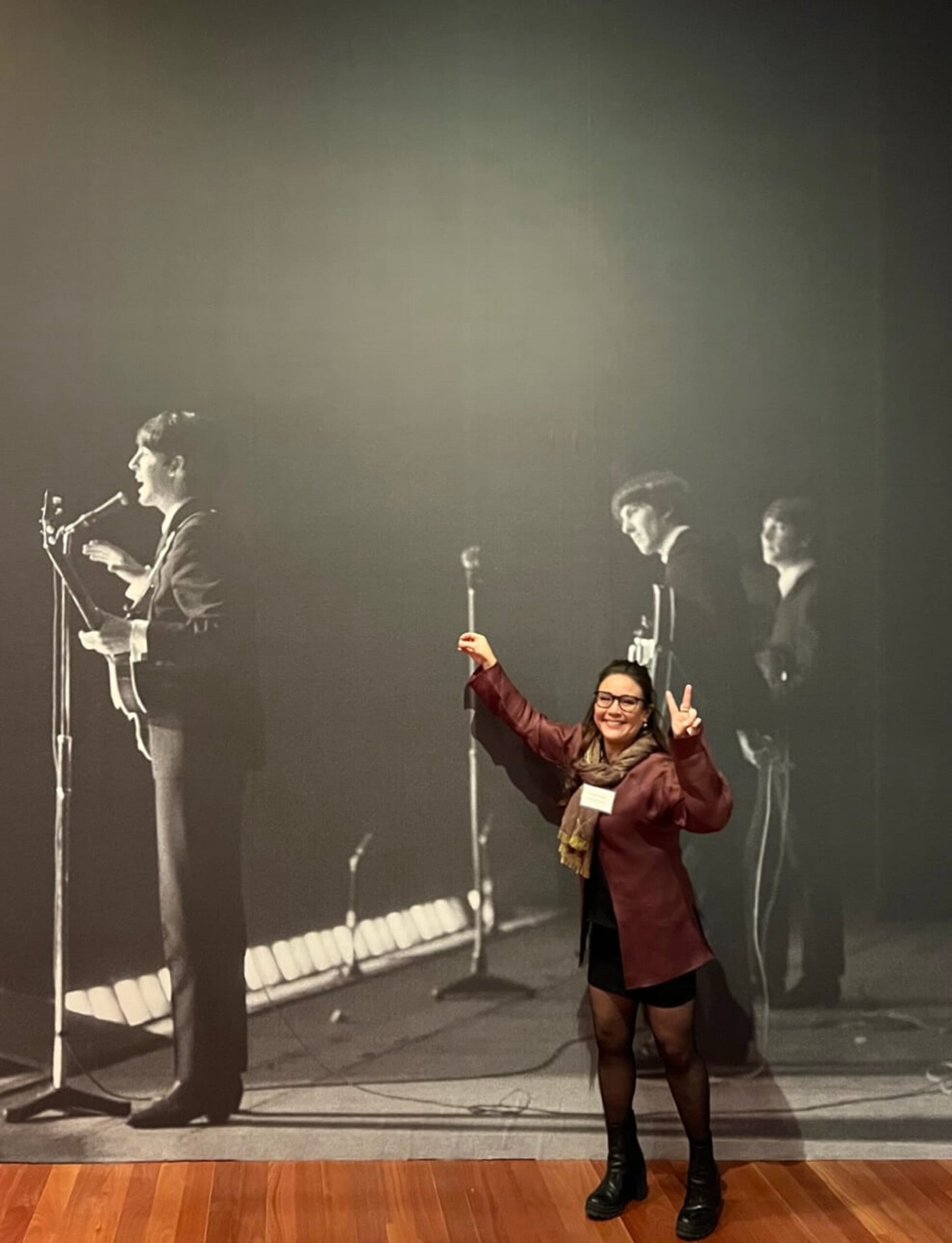 The Beatles’ entourage. The Beatles performing on tour, England, 1963. Photograph taken with Paul McCartney’s camera (flipped reproduction). Paul McCartney Photographs 1963–64: Eyes of the Storm. de Young Museum, SF. Posed in front of the work.