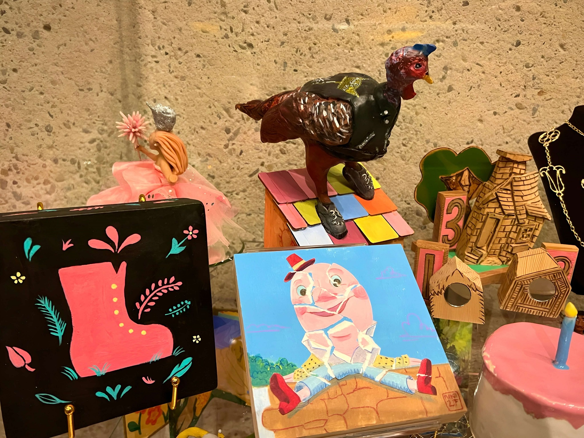 Fairyland @ 75: Works featuring Old Woman's Shoe by Simone Shin; Humpty Dumpty by Niki Toney; Birthday Cake by Kristin Farr; Pig Houses by Nathaniel Parsons; Turkey from Owl and the Pussy Cat by Miriam Stahl; and Glinda by Kimberly Rowe. OMCA, Oak.