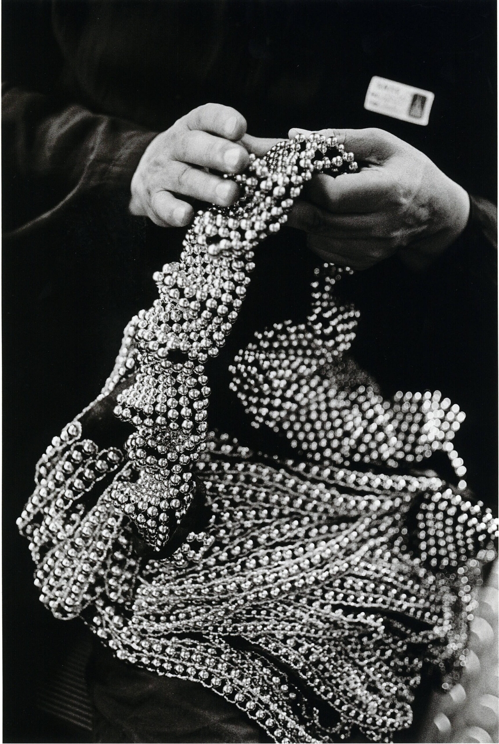 Azzedine Alaïa adjusting beads on a dress in Paris, 1989, photographed by Peter Lindbergh.